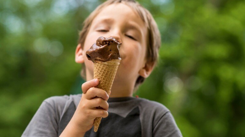 Niño comiendo helado de chocolate en cucurucho