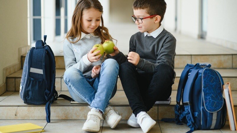 Niños a la salida del cole compartiendo unas manzanas