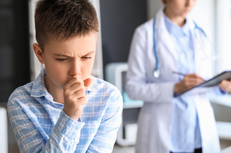 niño tosiendo en la consulta del medico