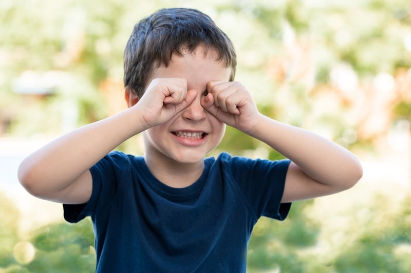 niño se frota los ojos